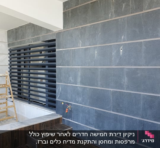 סולם עץ ליד קיר עם ברז מים